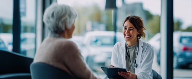 Une femme médecin s'entretient avec un patient âgé dans une atmosphère calme et détendue.