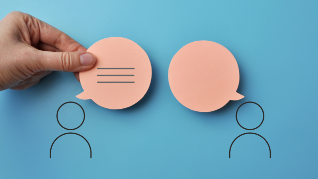 Main tenant une bulle de dialogue vers l'autre, symbolisant la communication entre deux personnes.