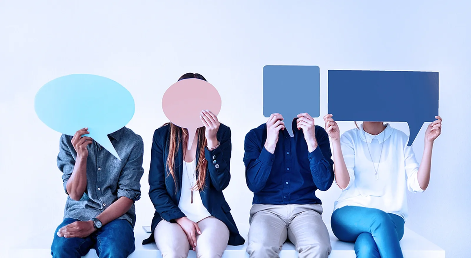 Quatre personnes tiennt des bulles de paroles colorées devant leurs visages.