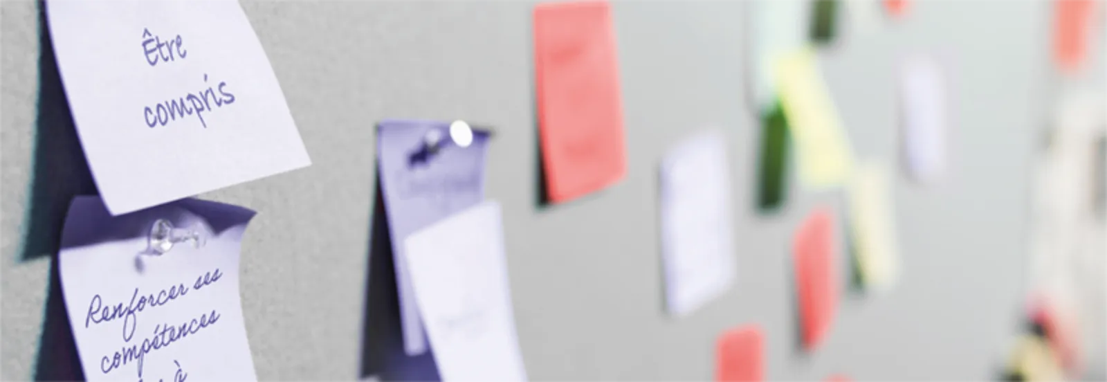 Des notes manuscrites épinglées sur une surface, dont une mentionnant « Être compris » et « Renforcer ses compétences ».